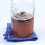 Fermenting Figs for yeast water in a Jar on a blue towel.