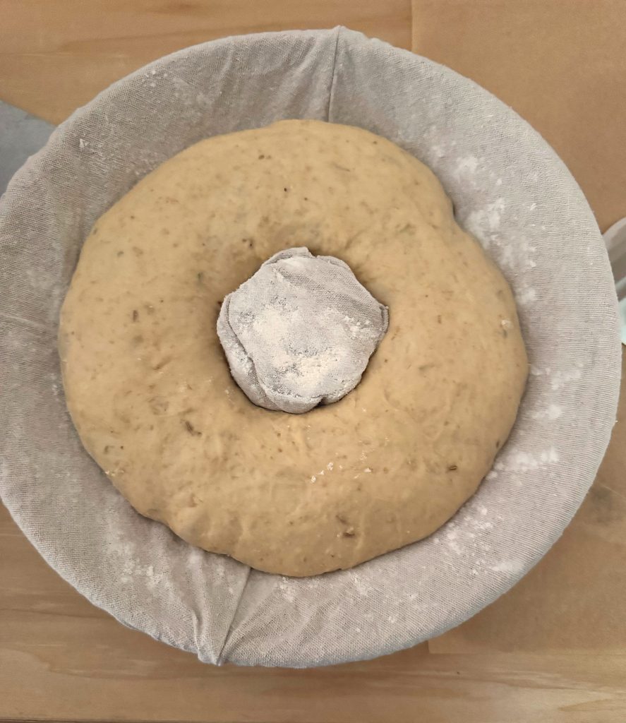 Proofed dough ring in a floured couronne proofing basket.