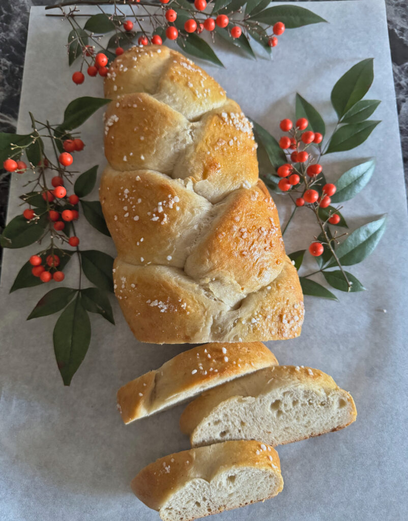 Sourdough Finnish Pulla Braid on parchment with leaves and berries
