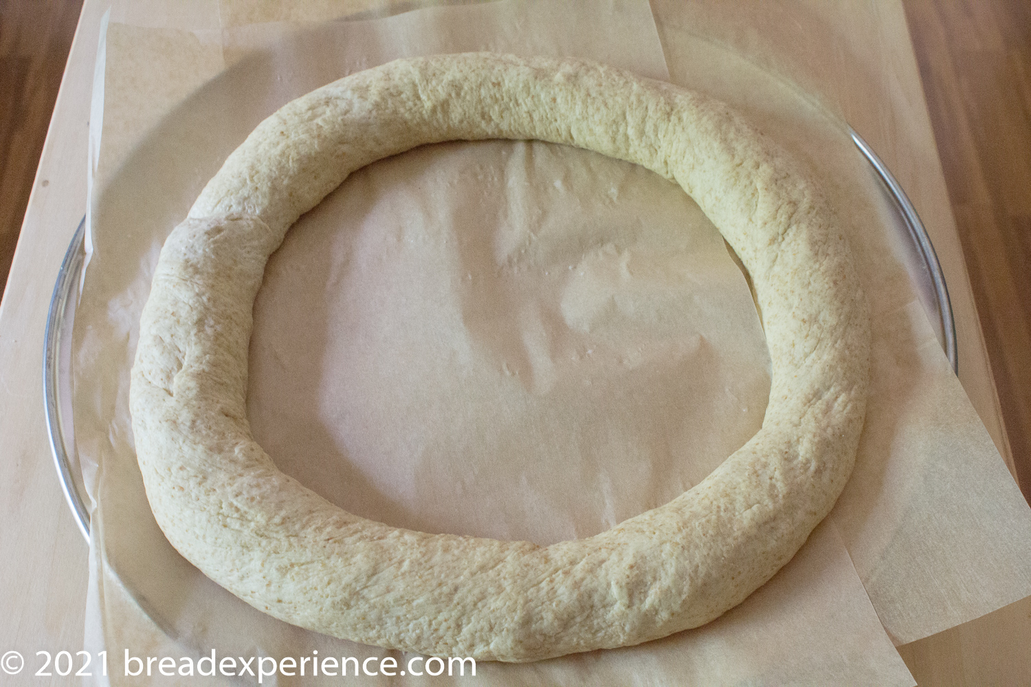 shaped wreath on parchment-lined pizza pan