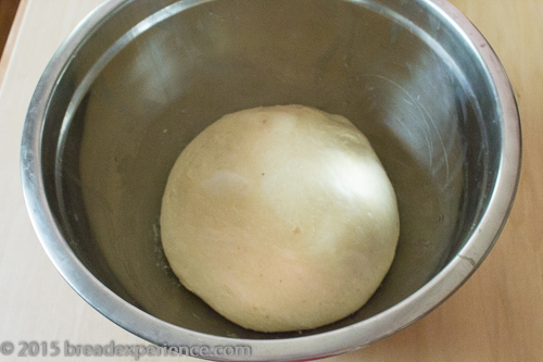 Smooth ball of sourdough Romanian Easter braid dough in a stainless steel bowl, ready for overnight fermentation.