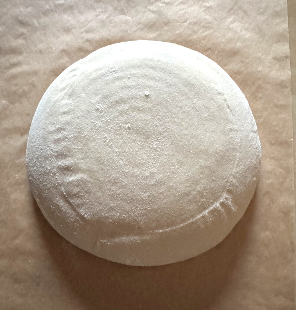 Simple Sourdough Boule resting on parchment after final proof and before scoring